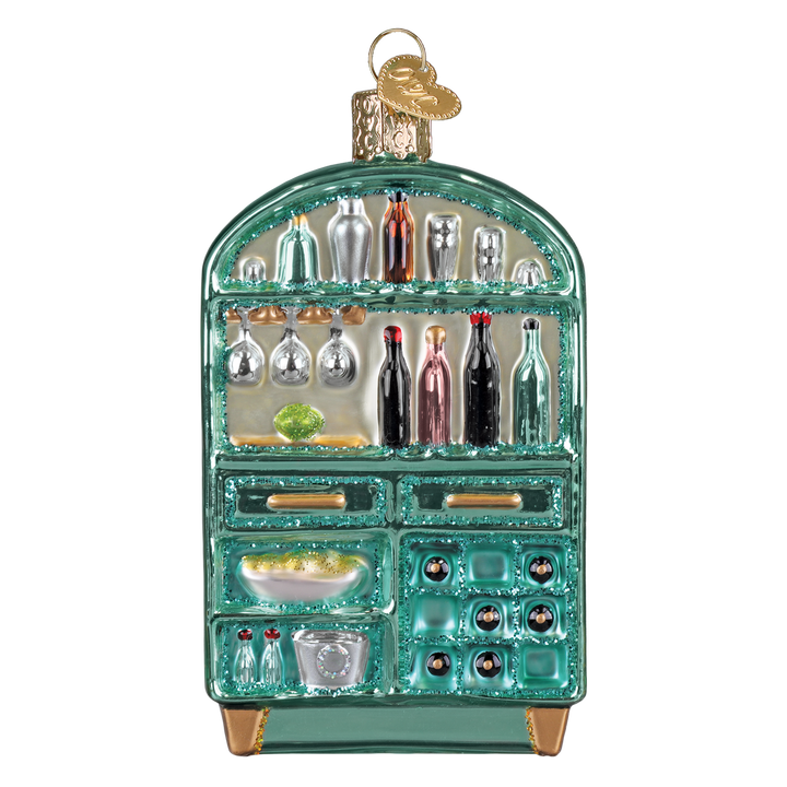 Teal glass bar cabinet Christmas ornament with painted liquor bottles and stemware on its shelves, front view on white