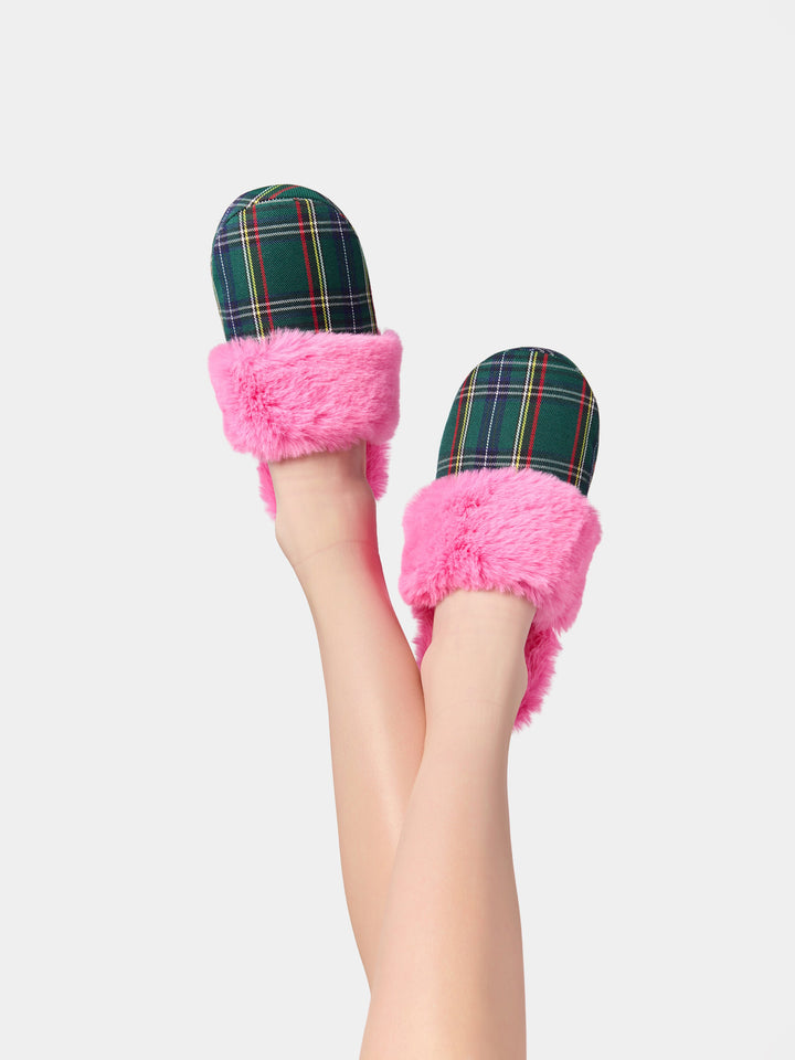 Legs raised wearing pink faux fur slippers with green plaid