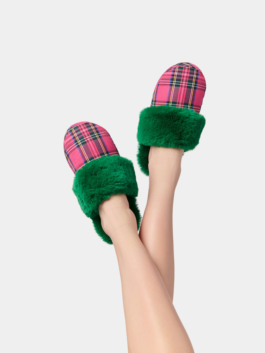 Green and red plaid slippers on raised feet
