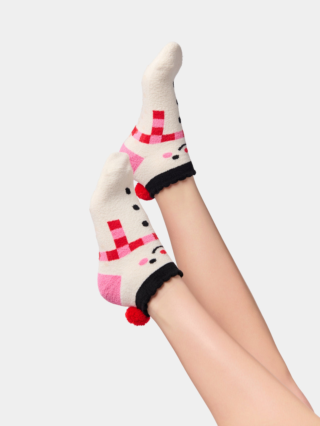 Side view of snowman socks showing the pink pom-pom and grip bottom