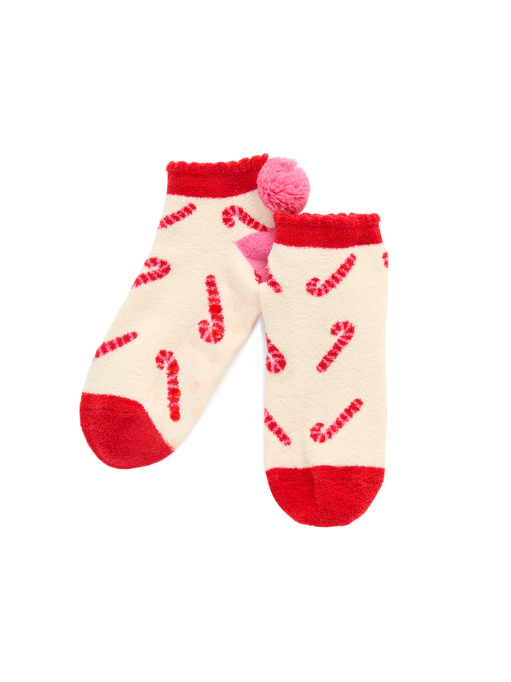 Ivory candy cane fuzzy socks with red trim and pom-poms on white