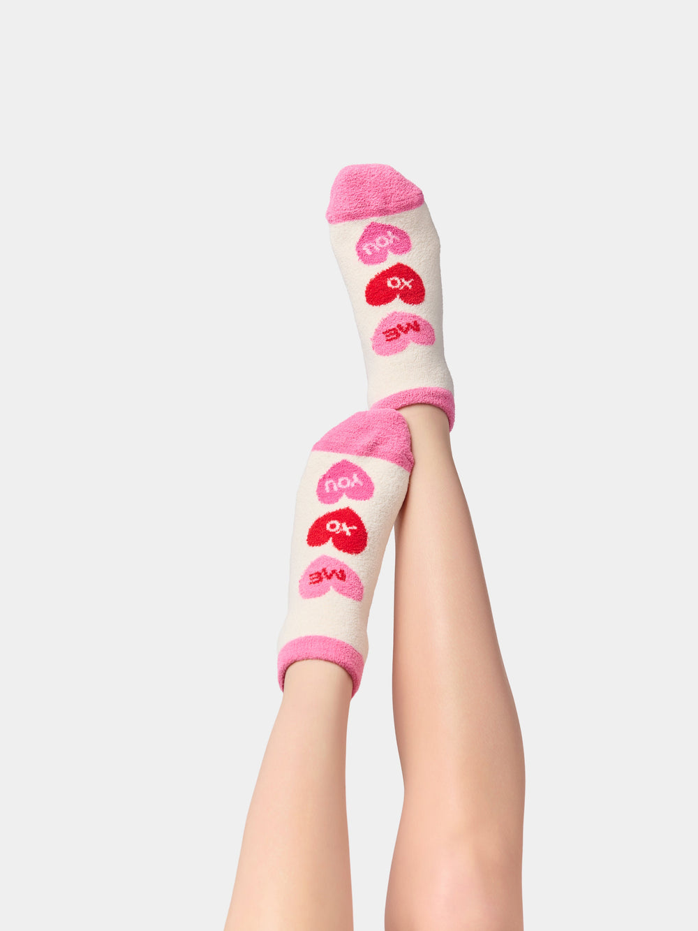 Legs raised wearing ivory conversation heart socks