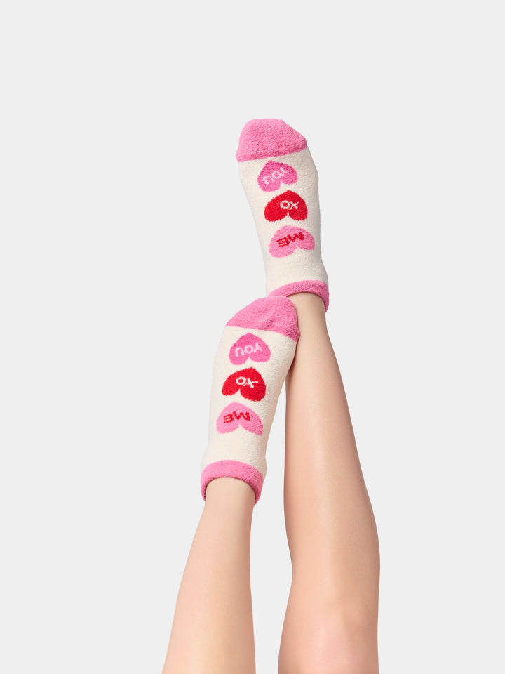 Legs raised wearing ivory conversation heart socks