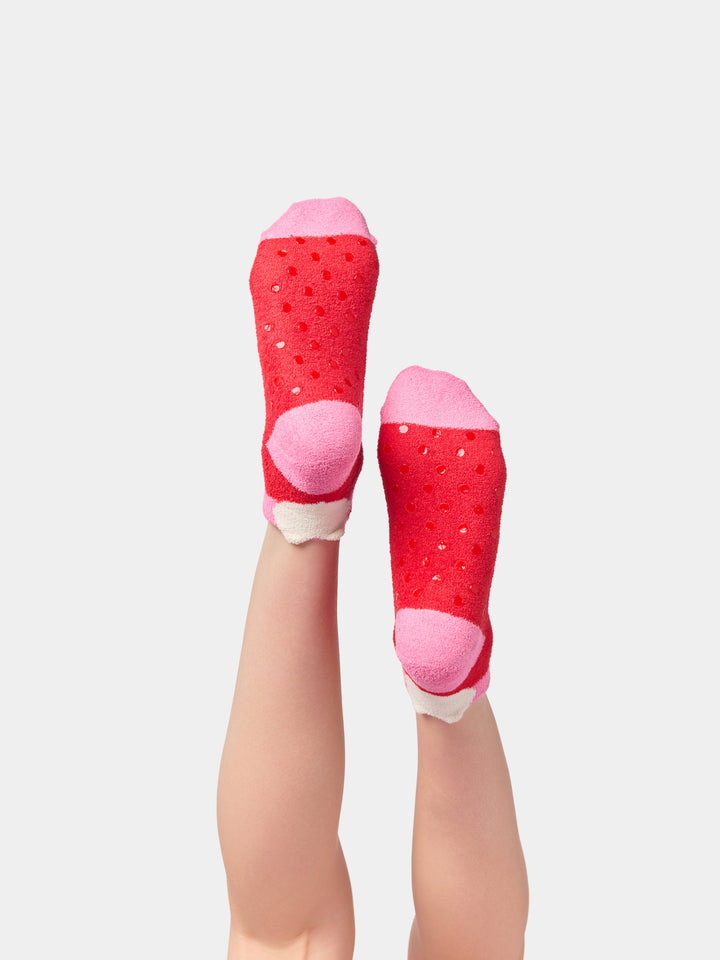 Red XO socks on raised feet showing pink heels