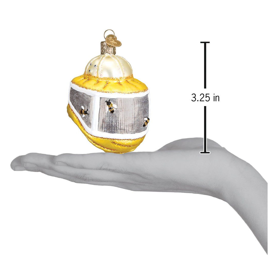 Beekeeper's hood ornament held above an open palm with a 3.25 inch height marker for scale