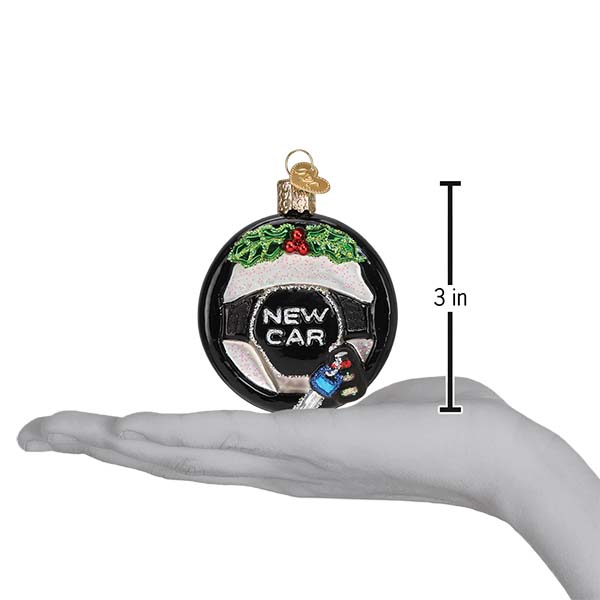 New Car steering wheel ornament resting on a hand with a 3 inch height marker for scale