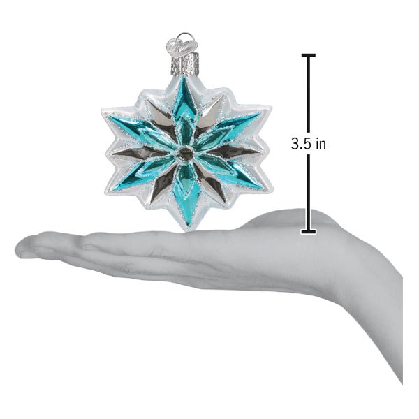 Snowflake ornament on an open palm beside a 3.5 inch height marker