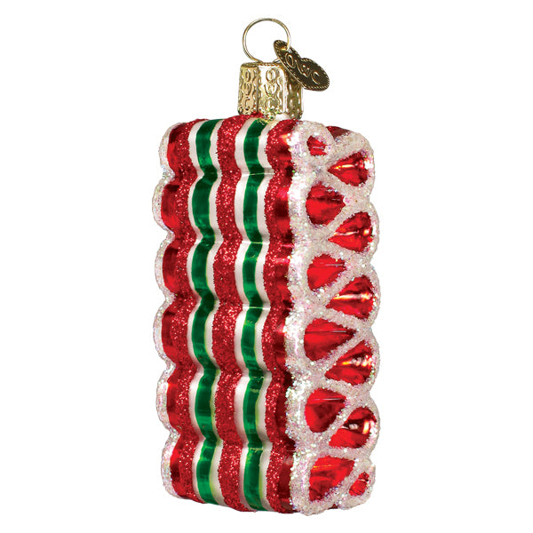 Red, white, and green striped ribbon candy glass ornament with gold cap, front view on white