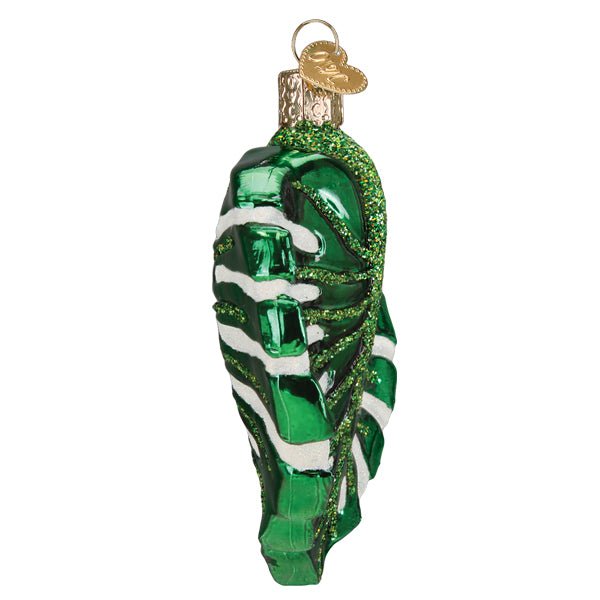Side view of the monstera leaf ornament showing its curved profile, on white