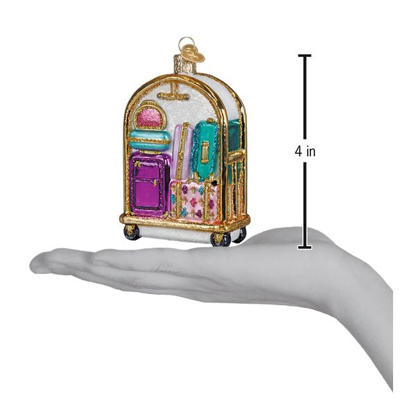 Luggage cart ornament held above an open palm with a 4 inch height marker for scale