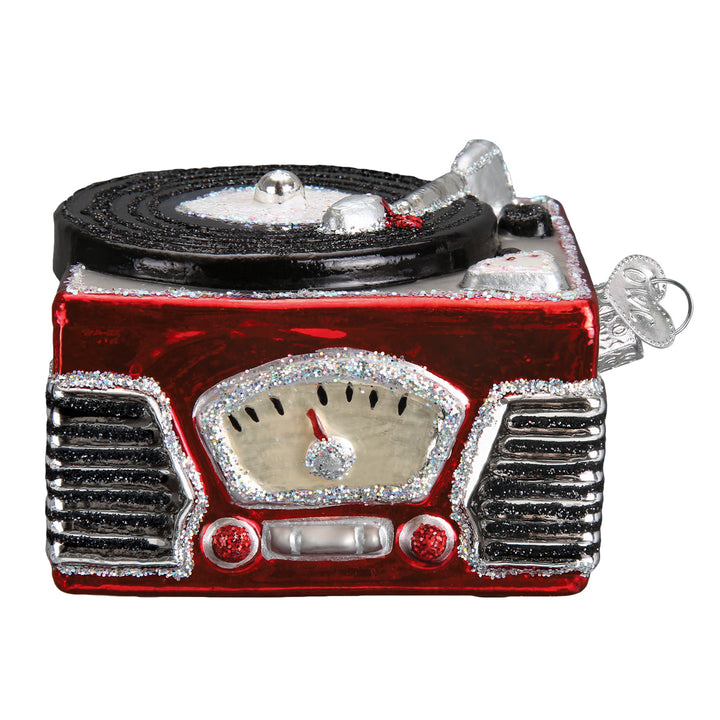 Front of the red record player ornament showing its radio dial and chrome speaker grille, on white