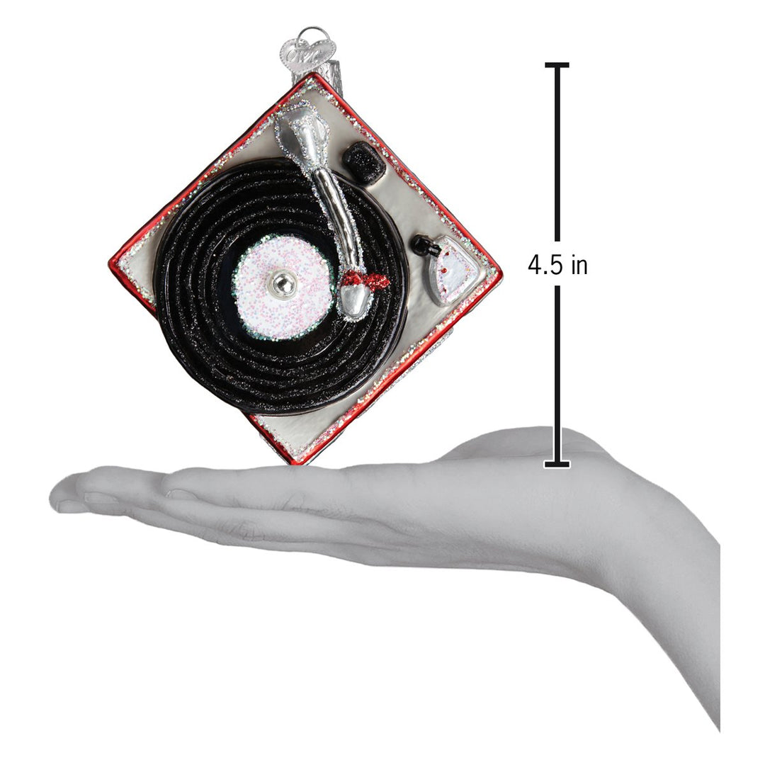 Record player ornament on an open palm beside a 4.5 inch height marker