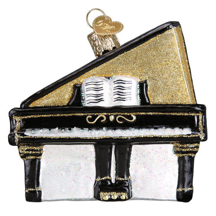 Front of the baby grand piano ornament showing white keys, sheet music, and gold trim, on white