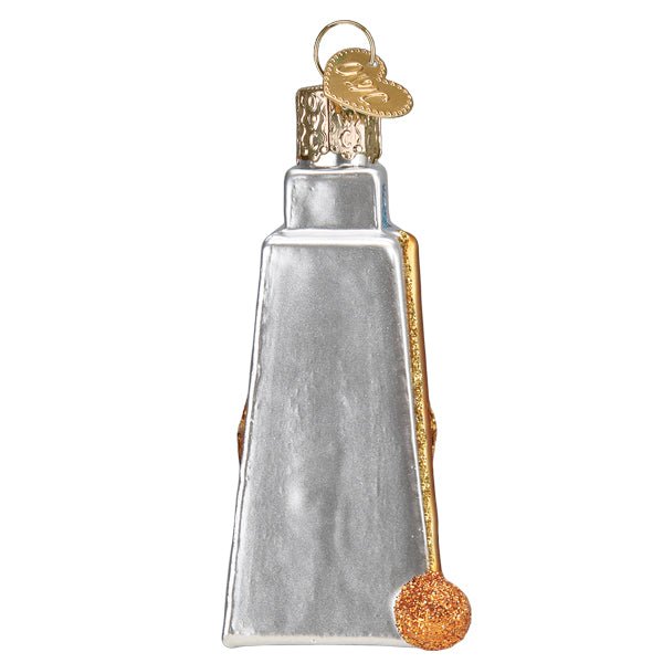Side view of the cowbell ornament showing the gold drumstick along its edge, on white