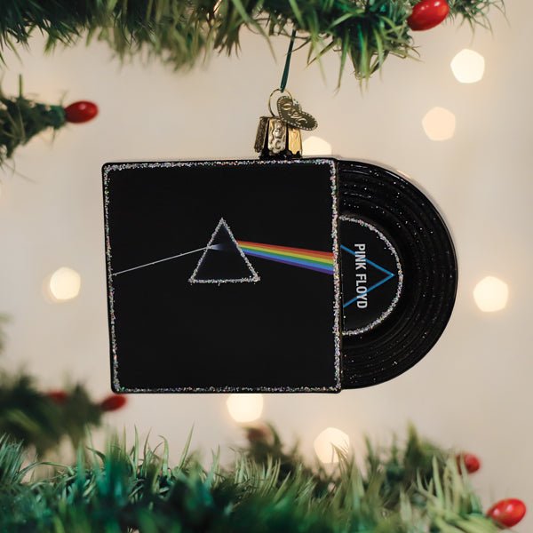 Pink Floyd album sleeve ornament with rainbow prism hanging on a lit Christmas tree with warm bokeh