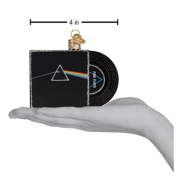 Dark Side of the Moon record ornament on an open palm beneath a 4 inch width marker