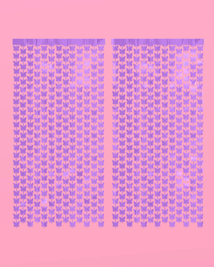 Two purple butterfly curtain panels hung side by side on a pink wall