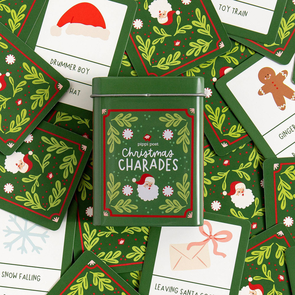 Christmas charades storage tin surrounded by festive prompt cards like drummer boy and toy train