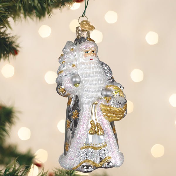 Silver Santa ornament hanging on a Christmas tree with soft golden lights behind