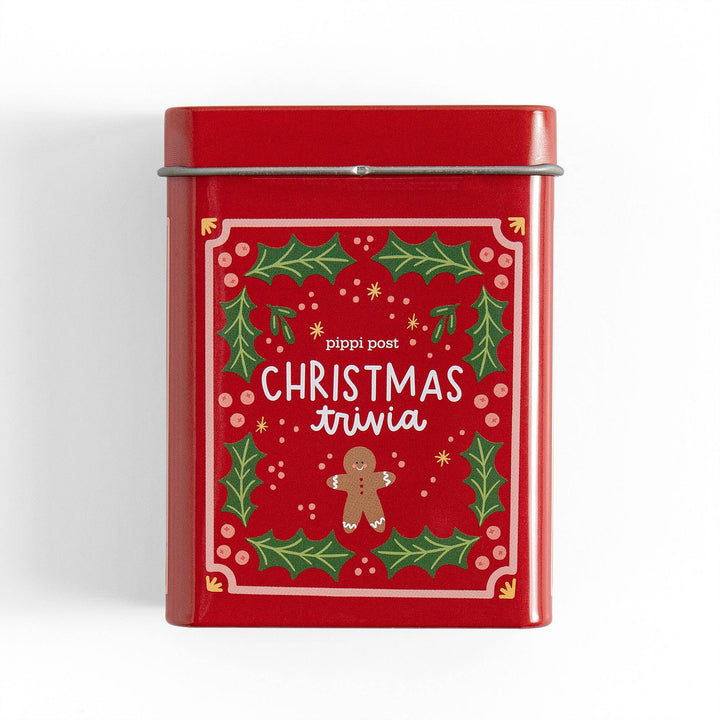 Red Christmas trivia tin with holly and gingerbread man artwork, a Christmas Eve game