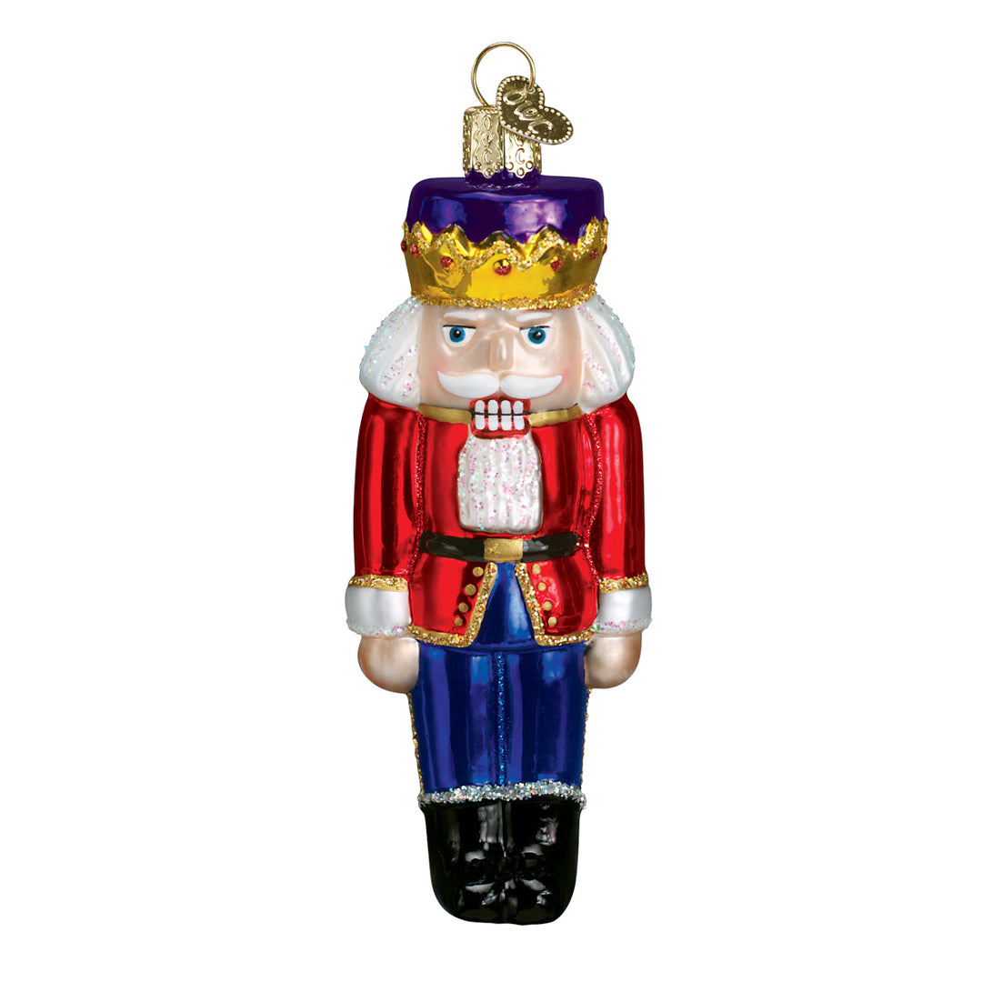 Front of the Nutcracker Prince ornament in a purple crown, red coat, and blue trousers, on white