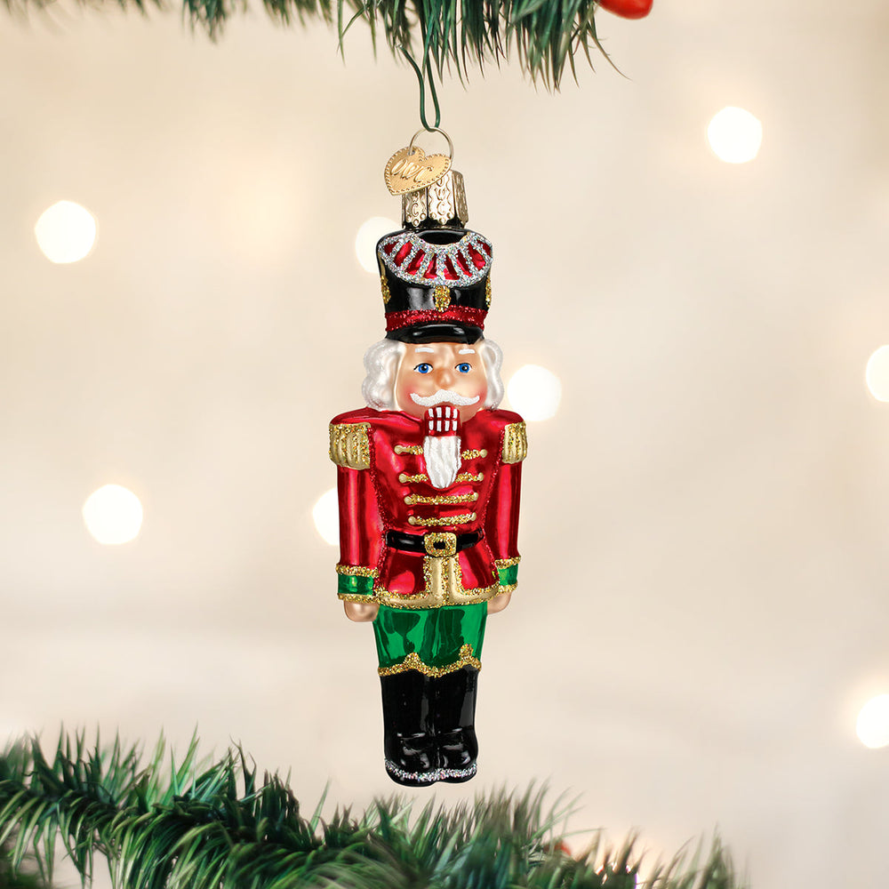 Nutcracker general glass ornament hanging on a lit Christmas tree
