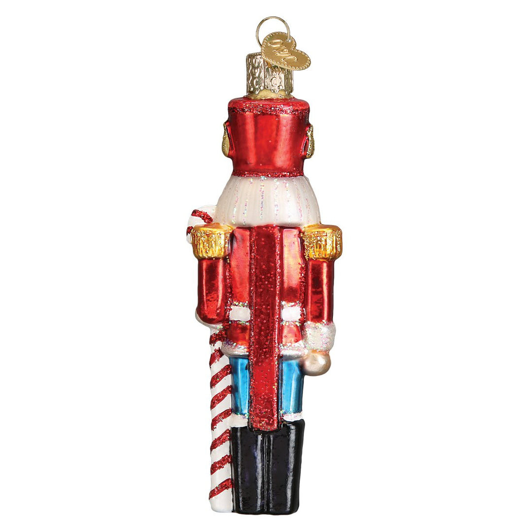 Back of the peppermint nutcracker ornament showing his red coat and hat, on white