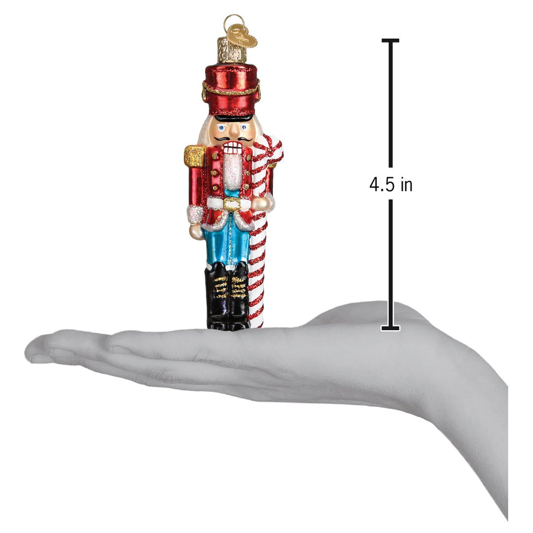 Peppermint nutcracker ornament on an open palm beside a 4.5 inch height marker