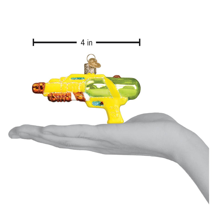 Squirt gun ornament on an open palm beneath a 4 inch width marker