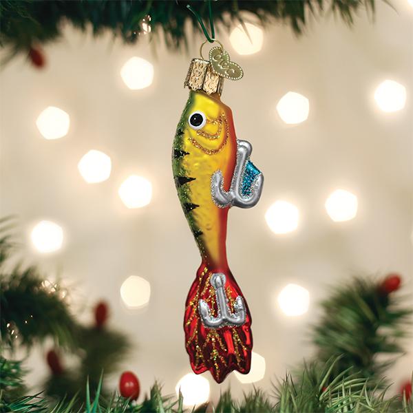 Fishing lure ornament hanging on a lit Christmas tree with soft bokeh lights