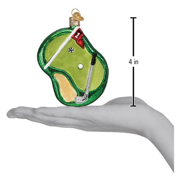 Putting green ornament on an open palm beside a 4 inch height marker