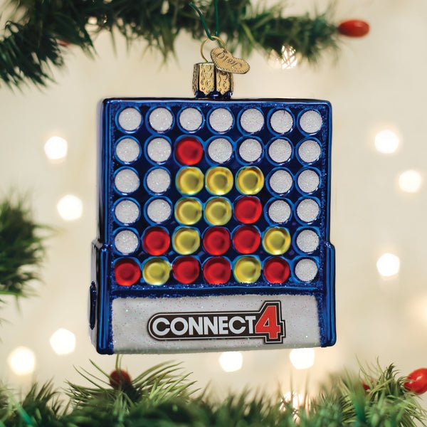 Blue Connect 4 game ornament hanging on a lit Christmas tree with warm bokeh lights