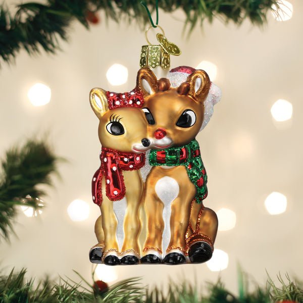 Rudolph and Clarice ornament hanging on a Christmas tree with soft holiday lights behind
