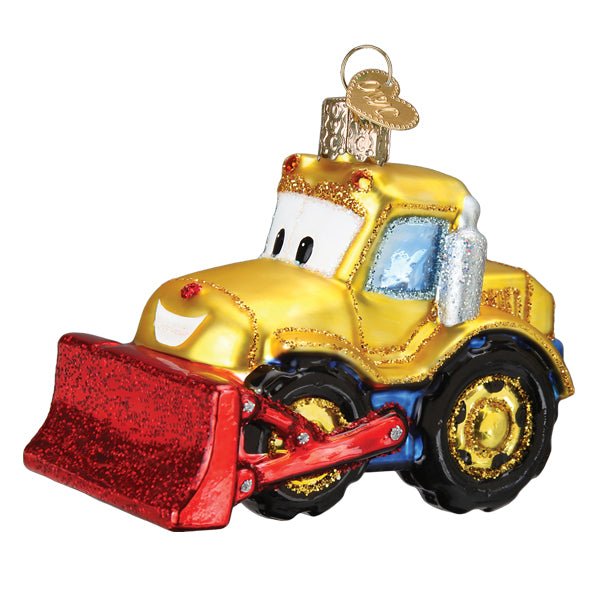 Three-quarter front view of the yellow bulldozer ornament with friendly eyes and a red glitter blade, on white