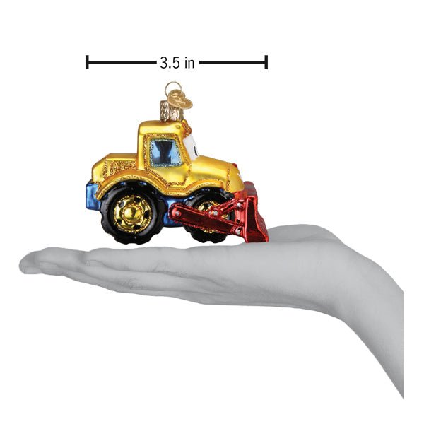 Bulldozer ornament on an open palm beneath a 3.5 inch width marker