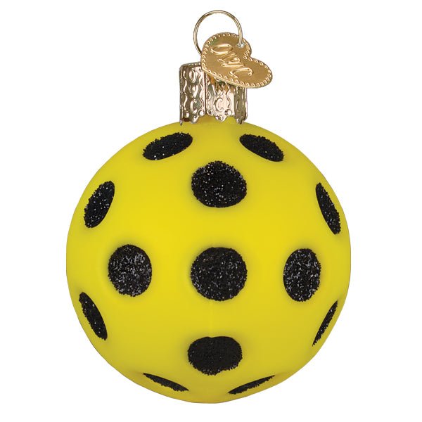 Front of the yellow pickleball ornament with glittered black holes and a gold cap, on white