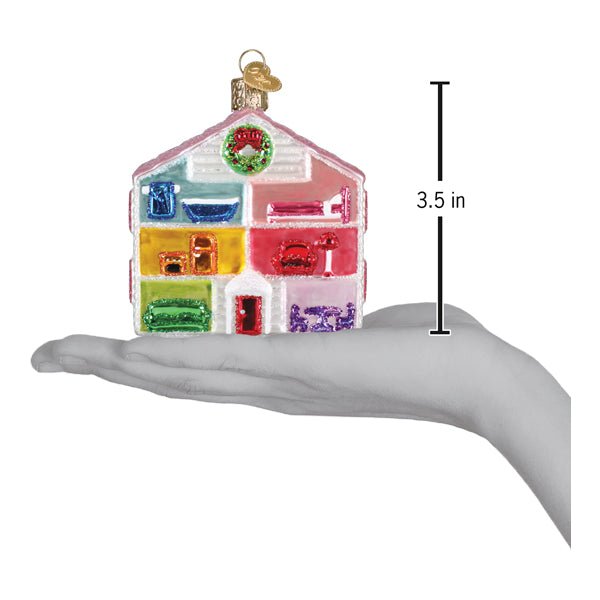 Dollhouse ornament on an open palm beside a 3.5 inch height marker