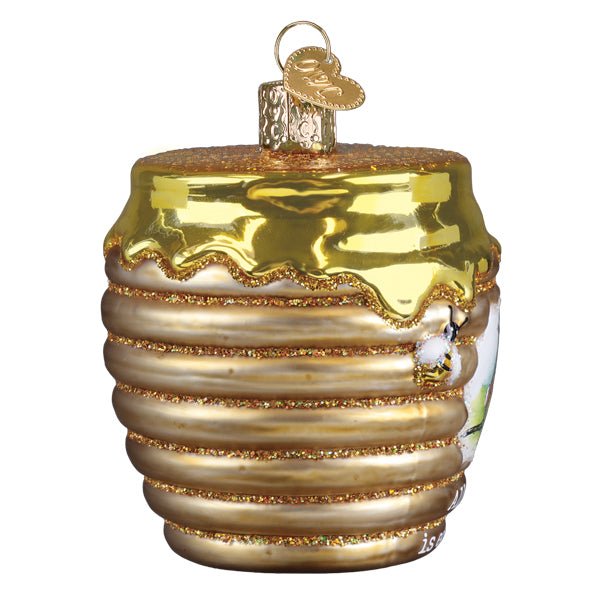 Honey pot ornament turned so the ribbed gold body and dripping honey lid face the camera