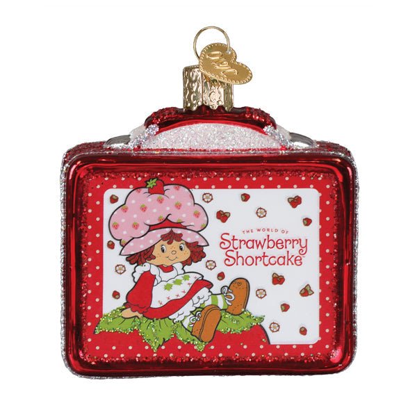 Angled front of the Strawberry Shortcake lunchbox ornament showing the glittered handle and gold cap