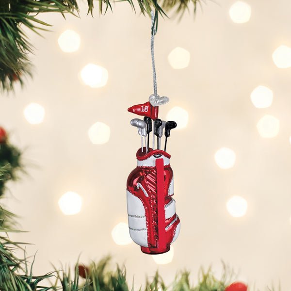 Golf bag ornament hanging on a Christmas tree branch with warm holiday lights behind