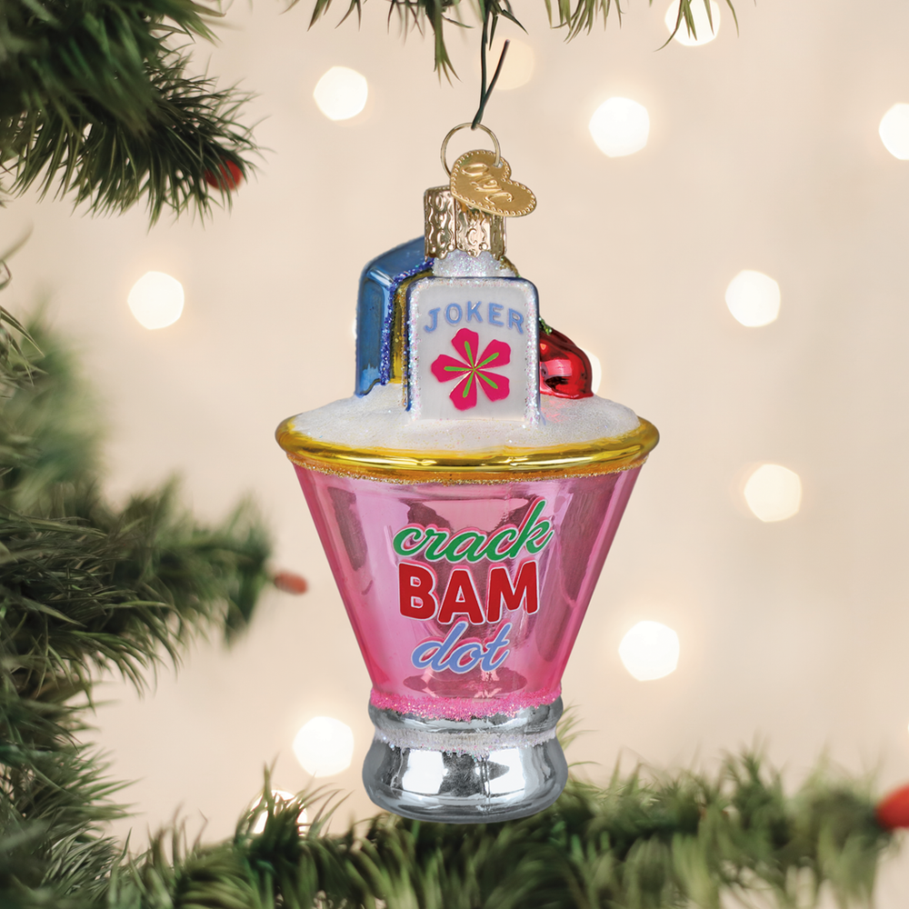 Mahjong martini glass ornament hanging on a Christmas tree with soft holiday lights behind