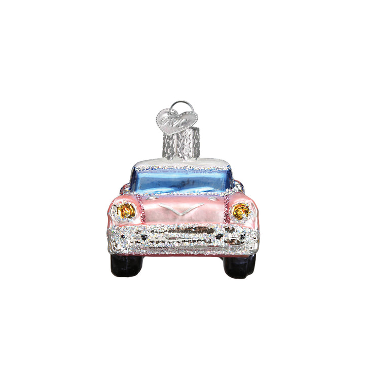 Front view of the pink classic car ornament showing the chrome grille and blue windshield, on white