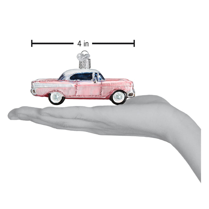 Pink classic car ornament on an open hand with a 4 inch scale marker above it