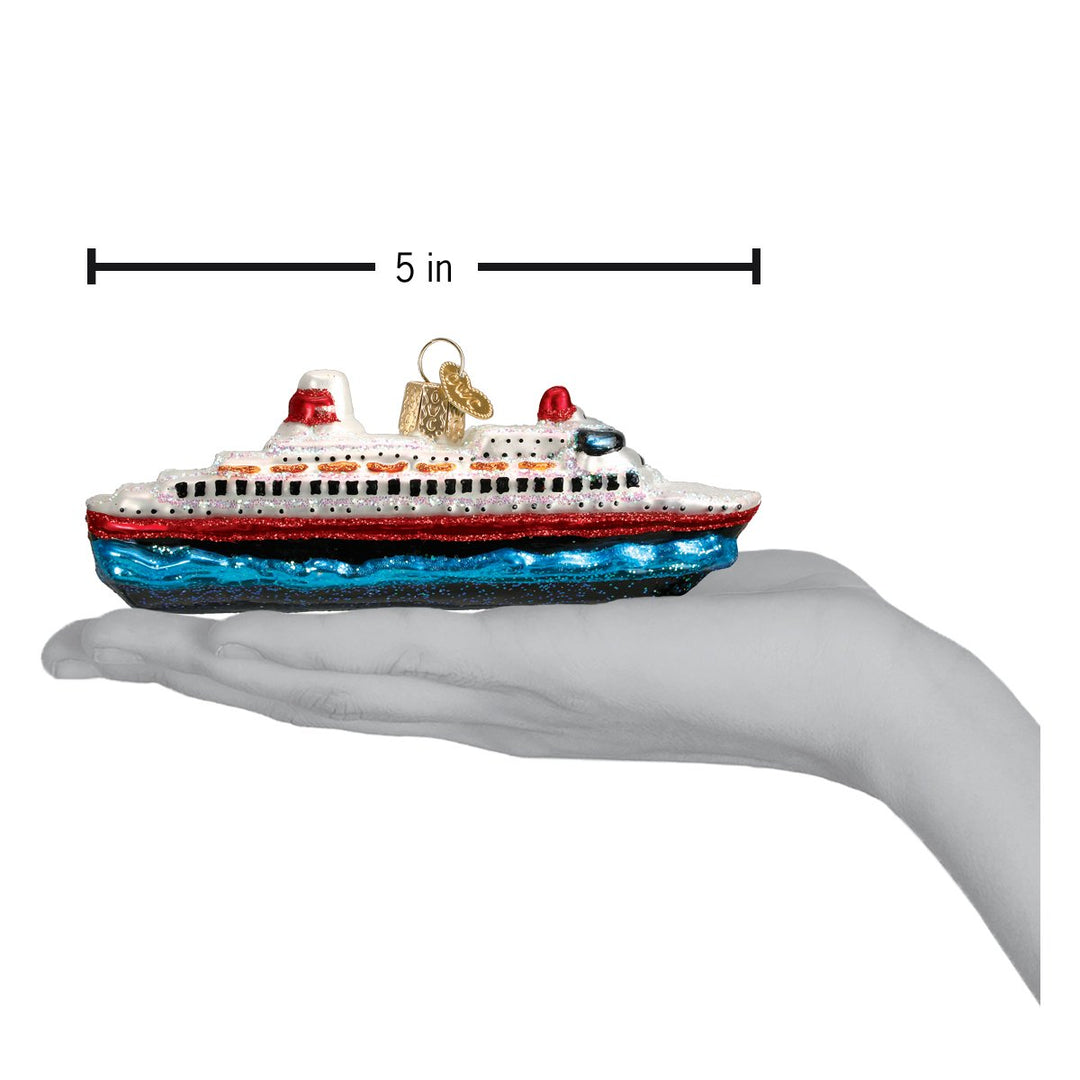 Cruise ship ornament resting on an open palm under a 5 inch length marker