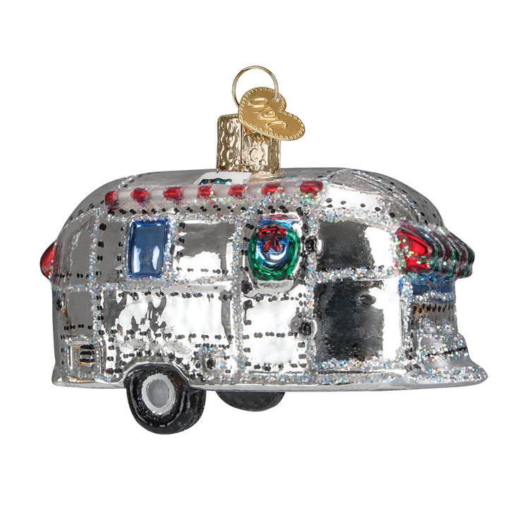 Shiny silver vintage camper trailer glass ornament, front view on a white background