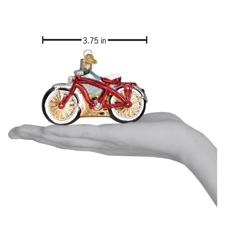 Red cruiser bike ornament resting on an open palm under a 3.75 inch length marker
