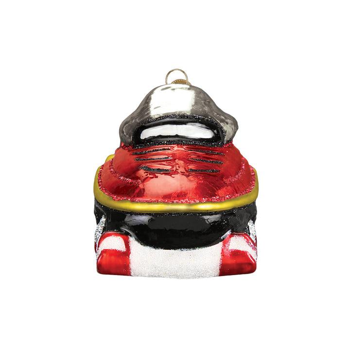 Front of the snowmobile ornament with its red hood and white skis