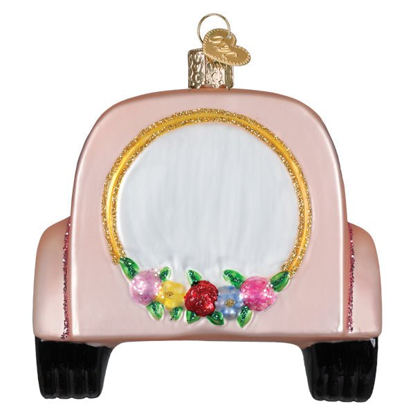 Front of the pink getaway car ornament with a gold oval and floral garland, on white