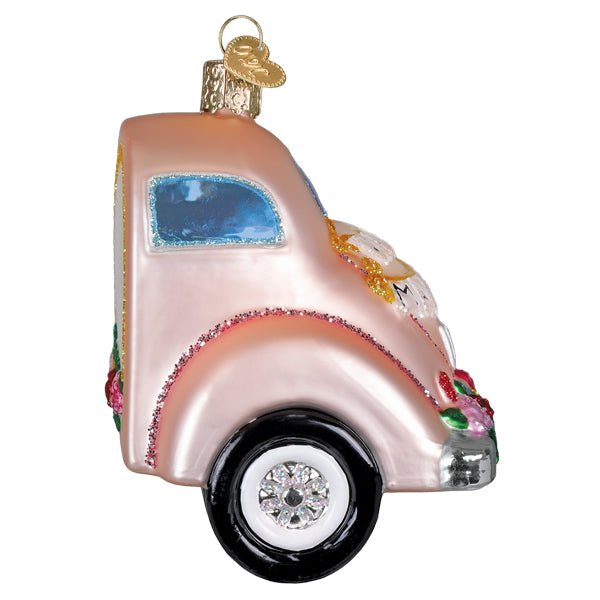 Side view of the pink Just Married car ornament showing its blue window and black tires
