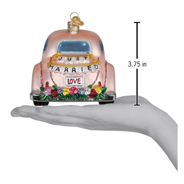 Just Married car ornament on an open palm beside a 3.75 inch height marker